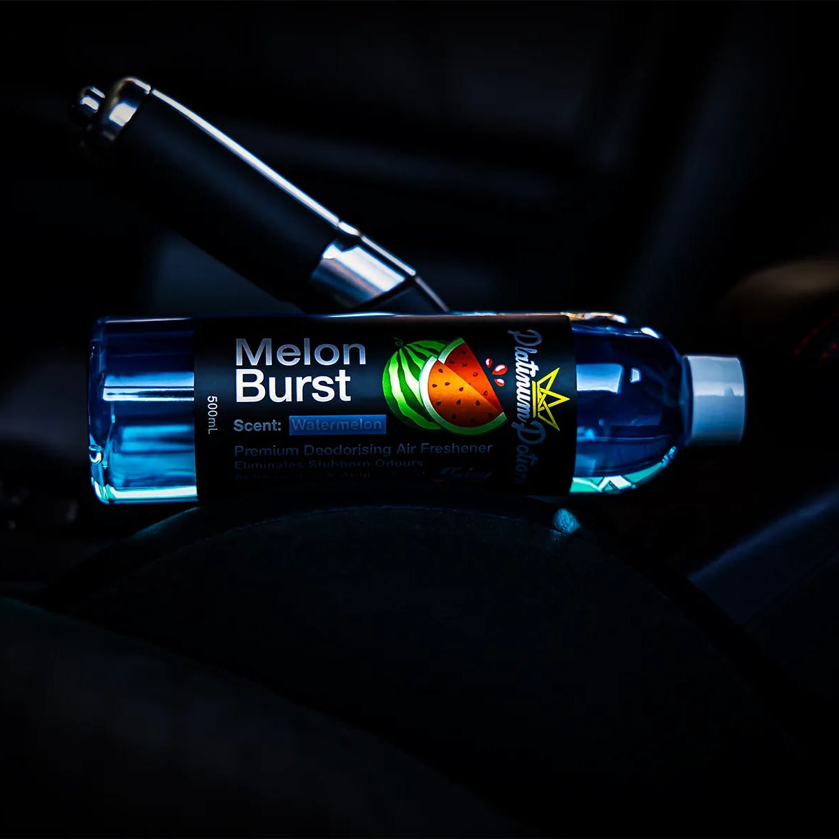 Melon Burst car air freshener bottle next to a car handbrake lever