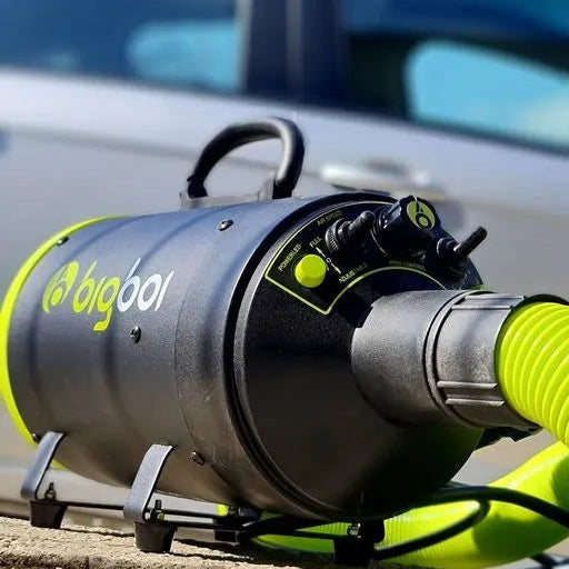 Black and yellow air dryer with a coiled hose on a gray background