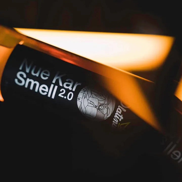 Product packaging with 'Nue Kar Smell 2.0' text on a dark background