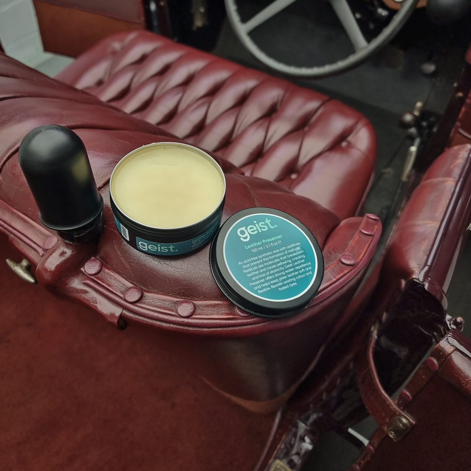 Two containers of 'geist' product on a vintage car seat