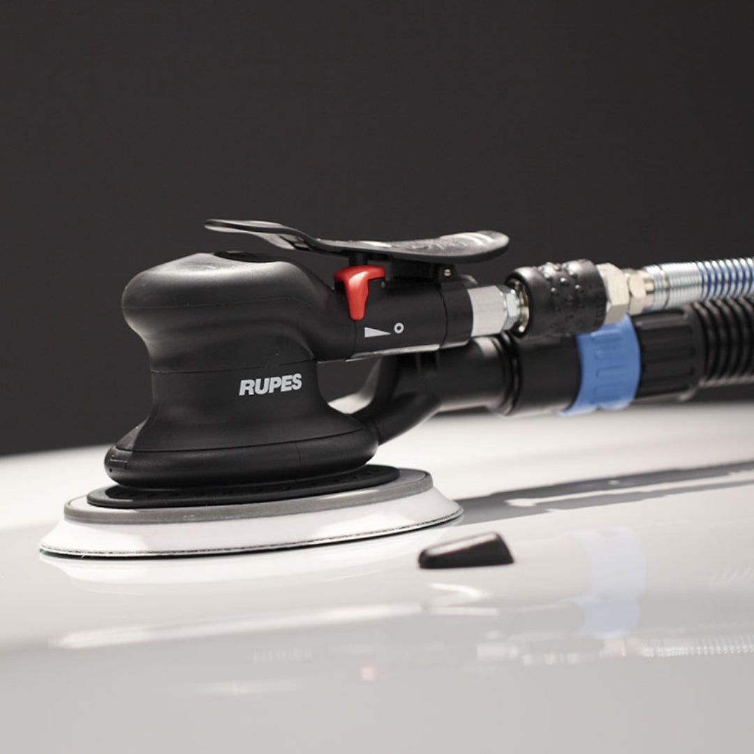 Rupes Skorpio III palm sander connected to dust extractor hose, sanding automotive clear coat