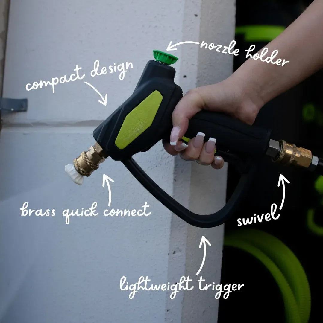 Hand holding a garden hose nozzle with labeled features on a white background