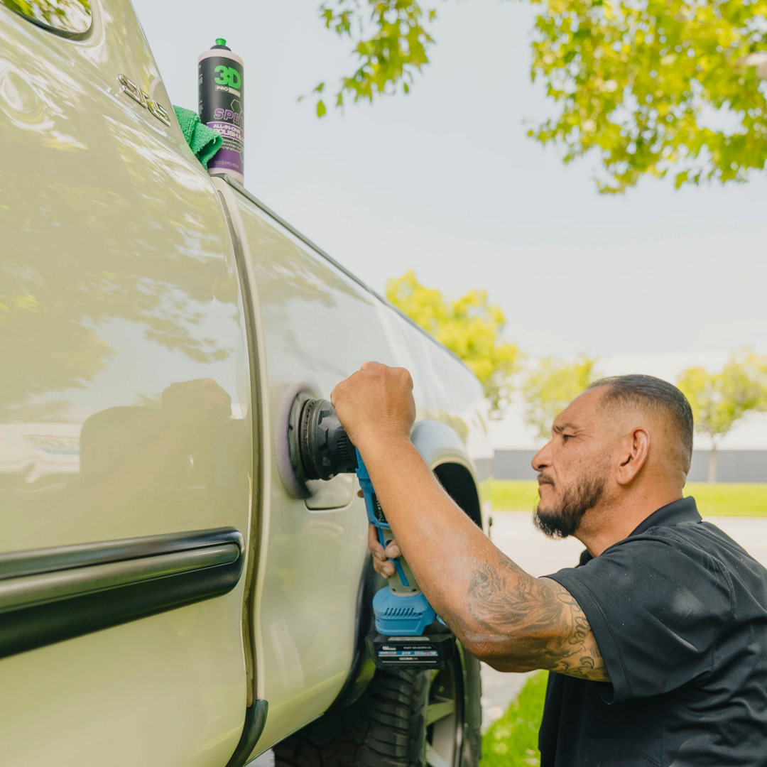 The Detail Warehouse technician using a dual action polisher to apply 3D Speed polish to a light-colored pickup truck.