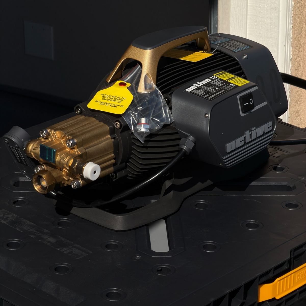 The Detail Warehouse Active 3.0 pressure washer featuring a brass 5-piston pump and induction motor on a work table.