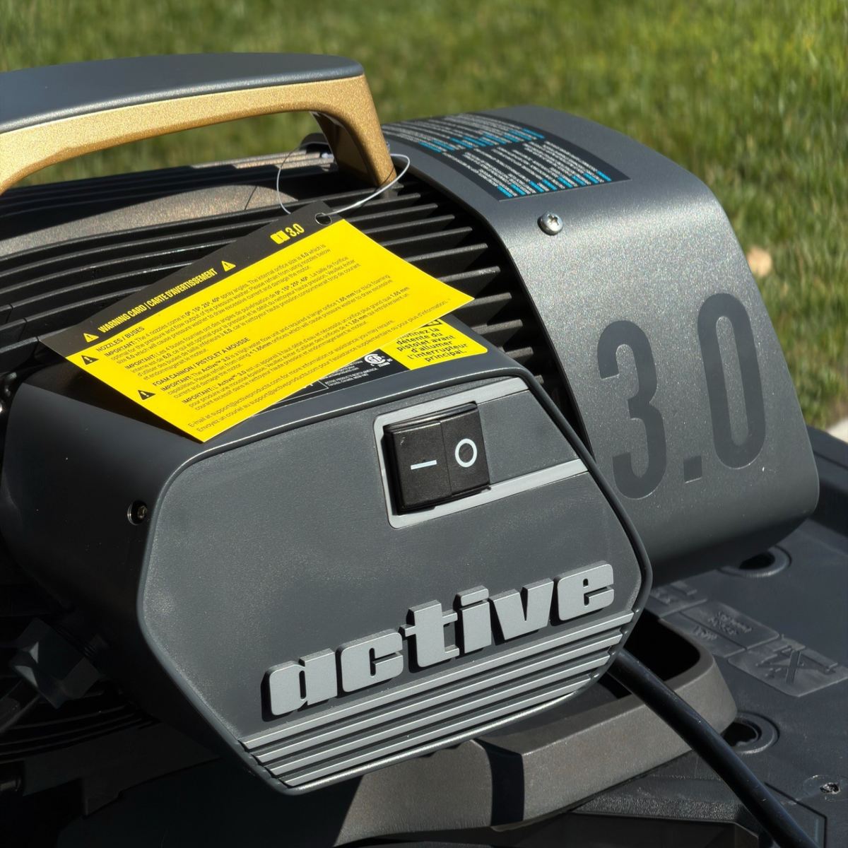The Detail Warehouse Active 3.0 pressure washer featuring a grey housing, gold handle, and power switch.