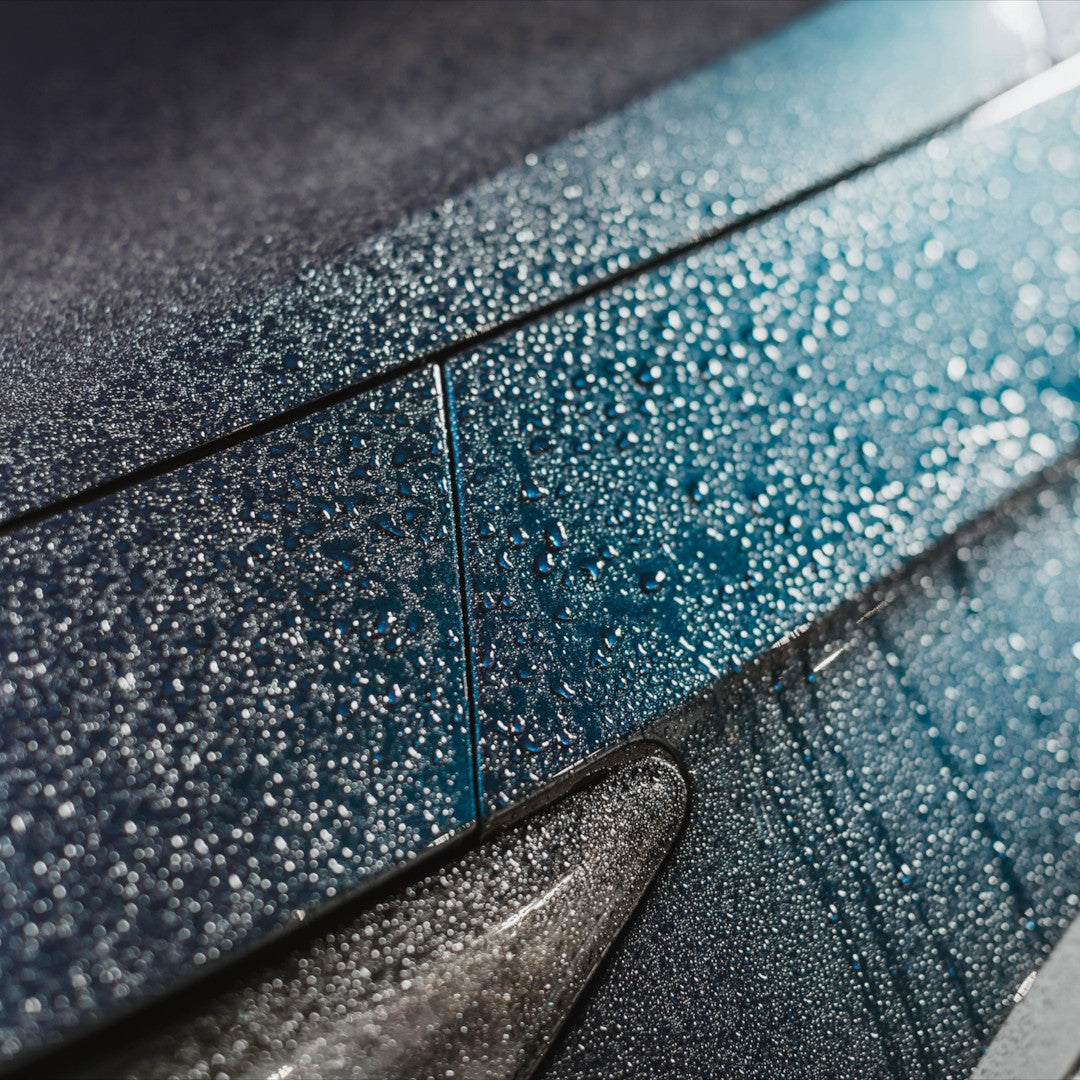 The Detail Warehouse Autoglym Aqua Wax showing hydrophobic water beading on a dark blue car paint surface