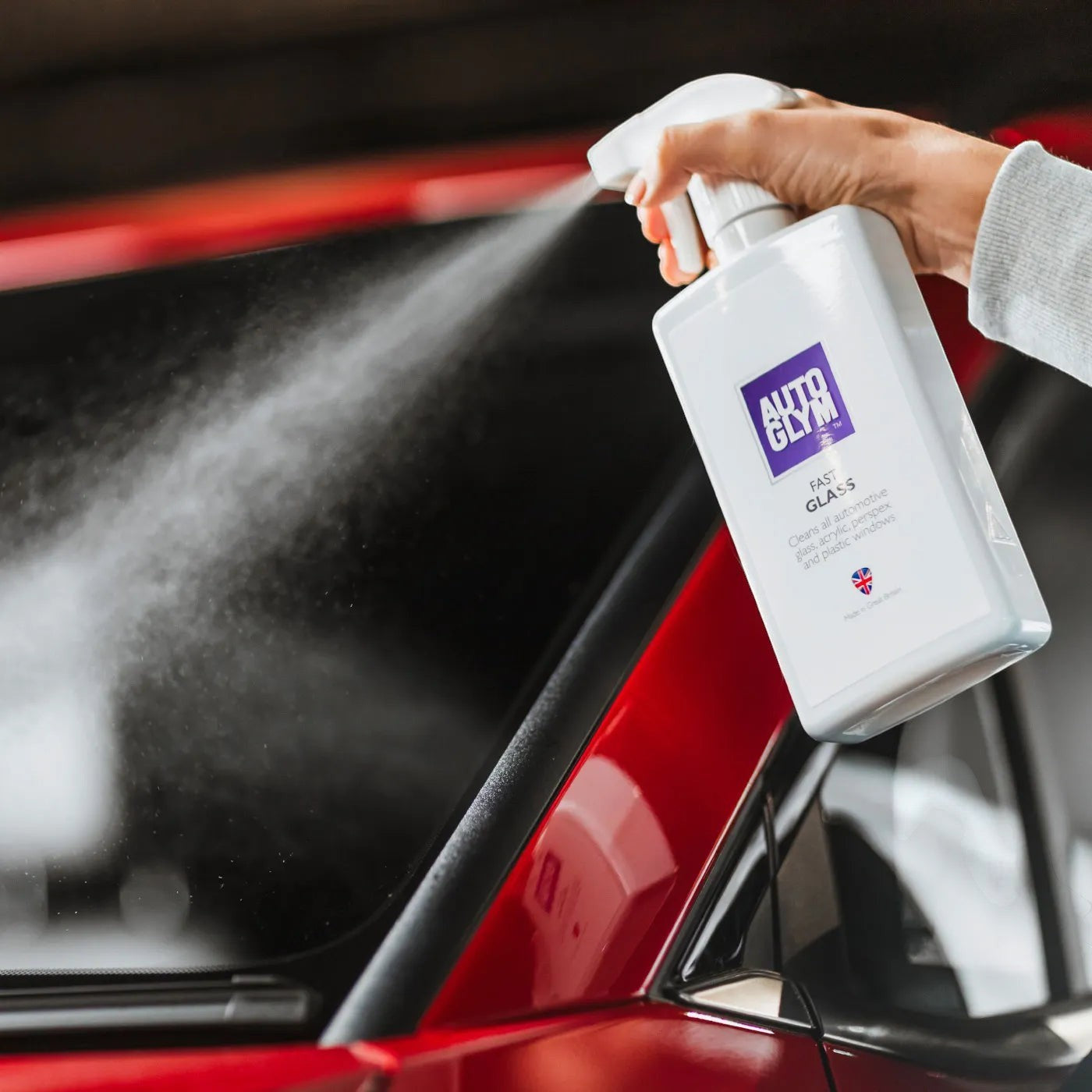 The Detail Warehouse Autoglym Fast Glass spray bottle being used to clean a car windscreen for a streak-free finish