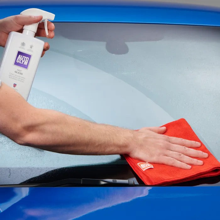 The Detail Warehouse Autoglym Fast Glass spray bottle being used with a red microfibre cloth to clean a car windscreen