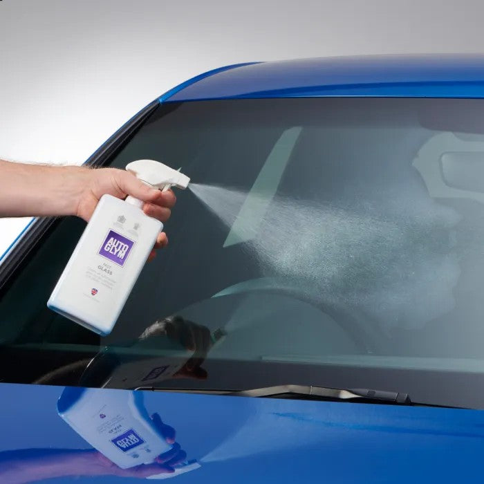 The Detail Warehouse Autoglym Fast Glass spray bottle being used to clean a car windscreen for a streak-free finish.