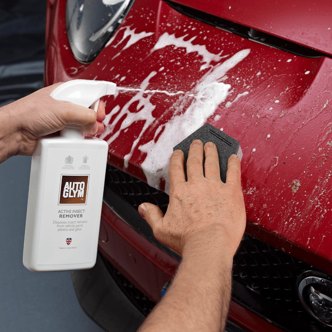 The Detail Warehouse Autoglym Active Insect Remover foam being sprayed and wiped off a red car hood with a sponge