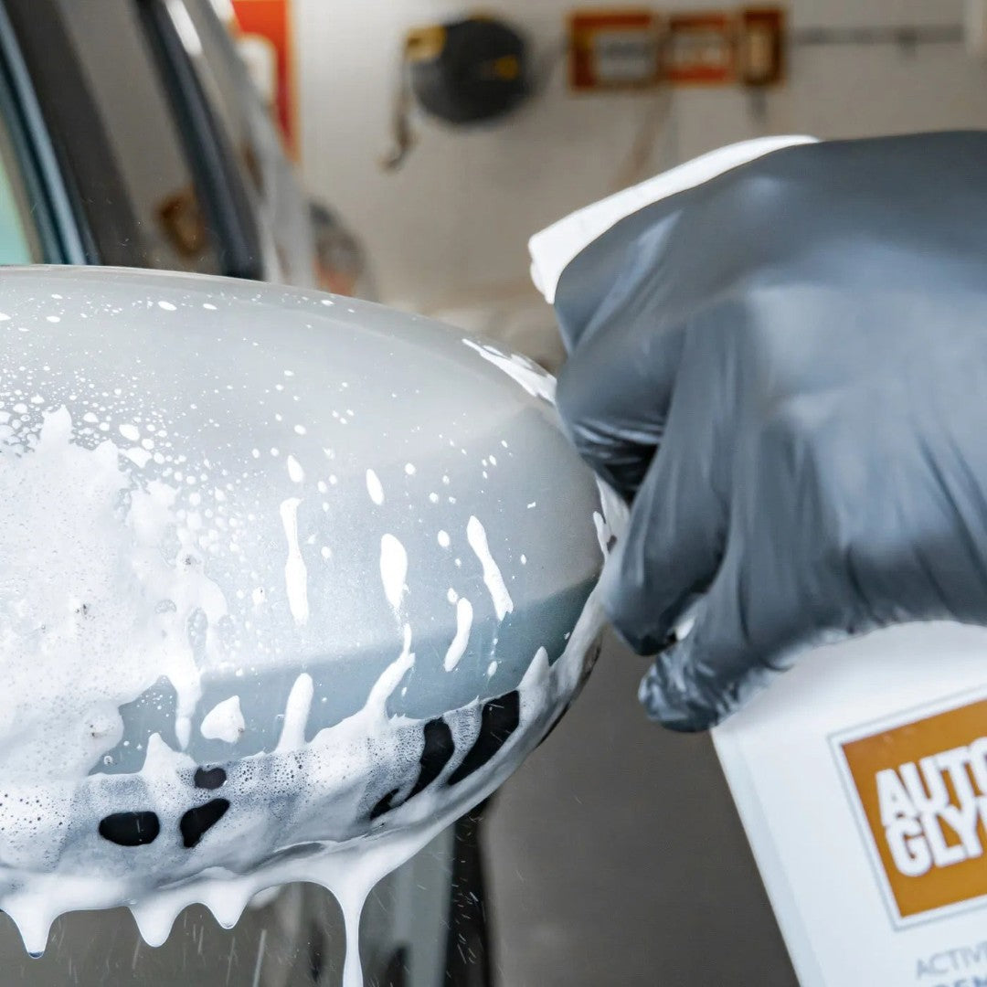 The Detail Warehouse Autoglym Active Insect Remover foam being sprayed onto a car side mirror to dissolve bug residue.