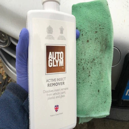 The Detail Warehouse Autoglym Active Insect Remover bottle held with a green microfiber cloth for car cleaning