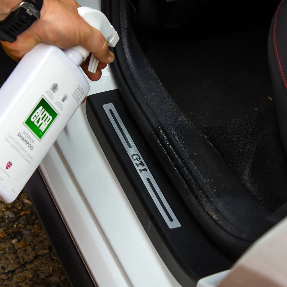 The Detail Warehouse Autoglym Interior Shampoo being sprayed onto a car door sill for cleaning