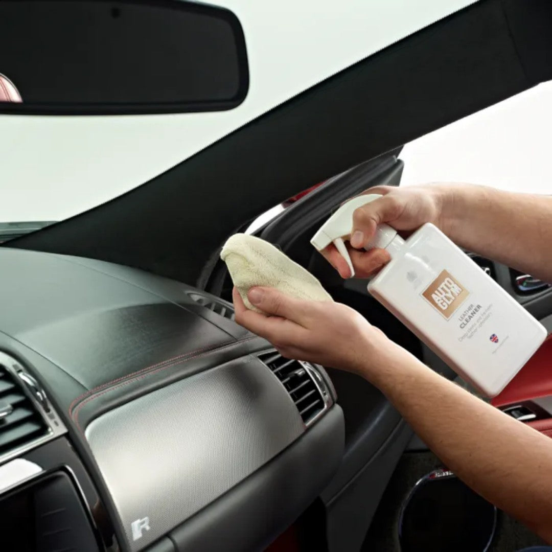 The Detail Warehouse Autoglym Leather Cleaner being applied to a car dashboard with a microfibre cloth