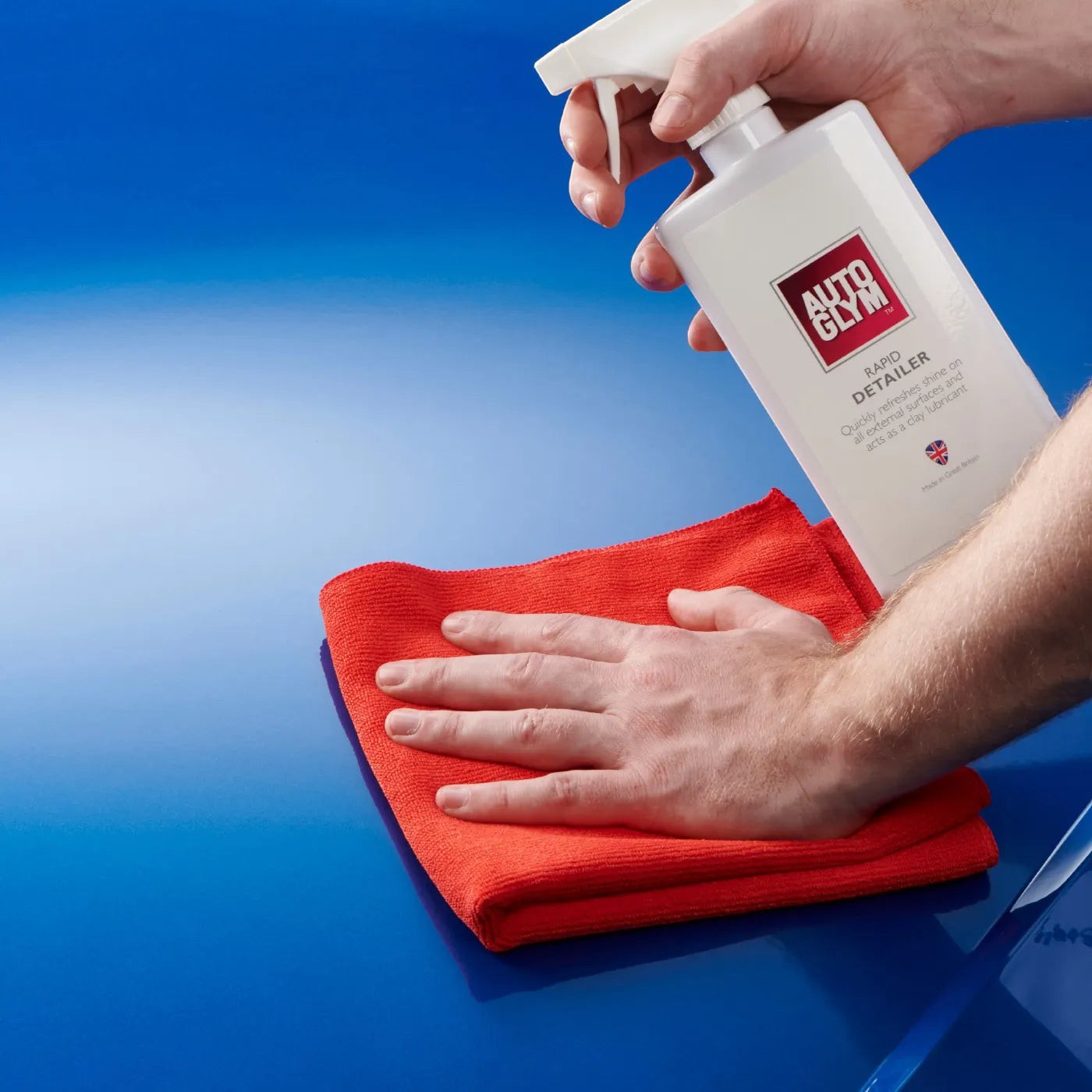The Detail Warehouse Autoglym Rapid Detailer spray bottle being used with a red microfiber cloth on a blue car hood