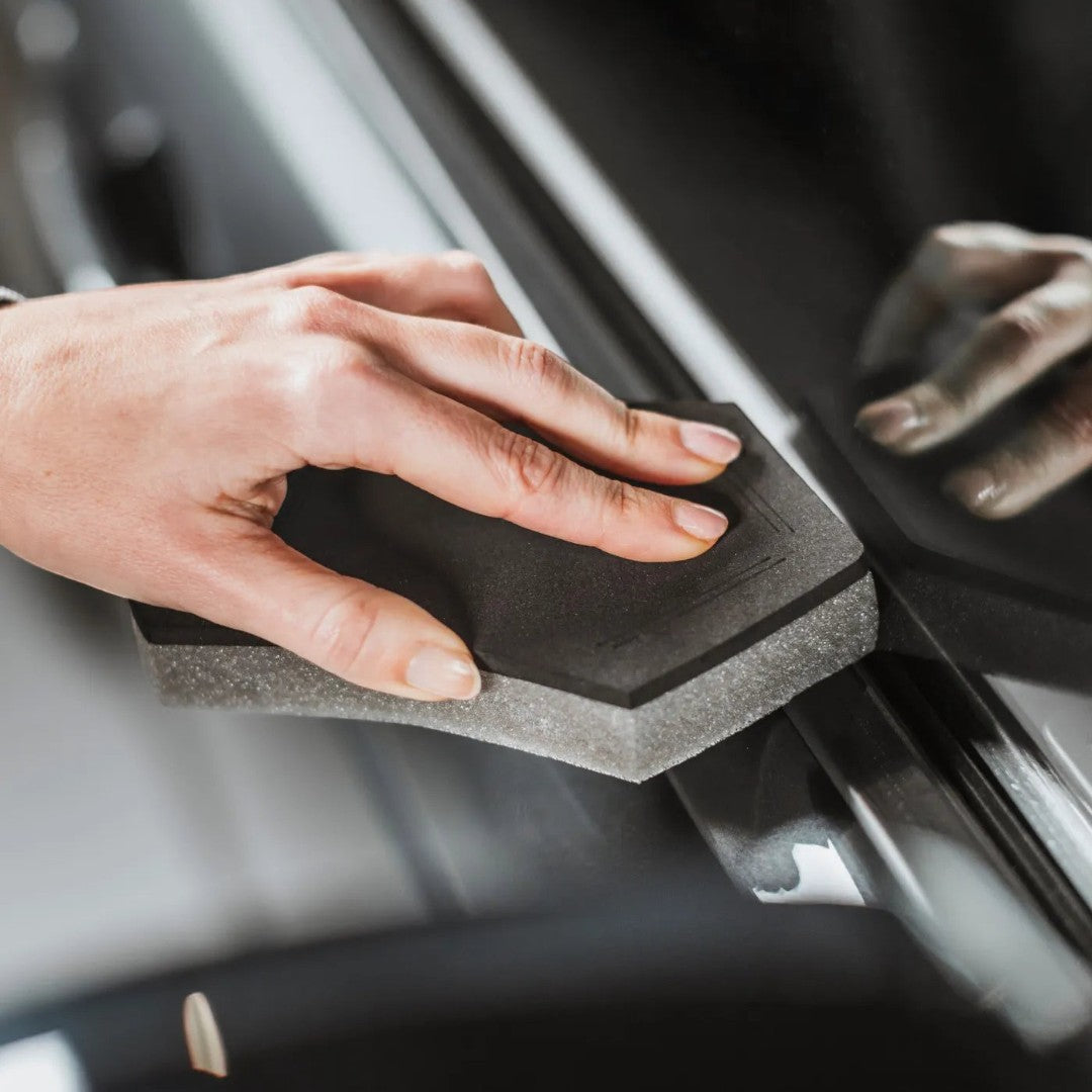 The Detail Warehouse hand using a black foam applicator to apply Autoglym Vinyl & Rubber Care to car trim