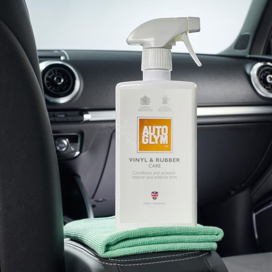 The Detail Warehouse Autoglym Vinyl & Rubber Care spray bottle with a microfibre cloth inside a car interior.