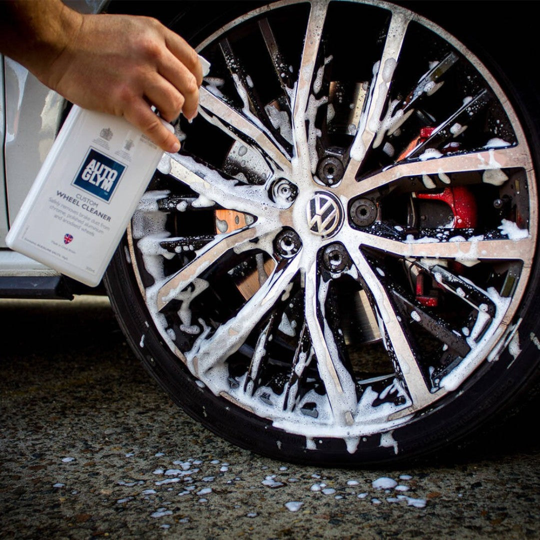 The Detail Warehouse Autoglym Custom Wheel Cleaner spray bottle applying foam to a dirty alloy car wheel