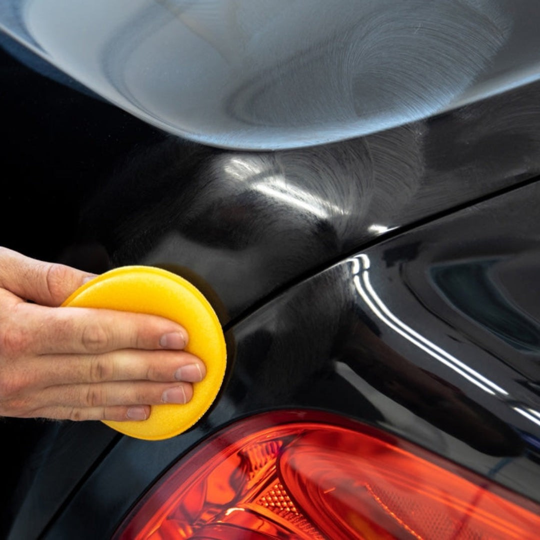 The Detail Warehouse yellow foam wax applicators stacked in two columns for car detailing and polishing