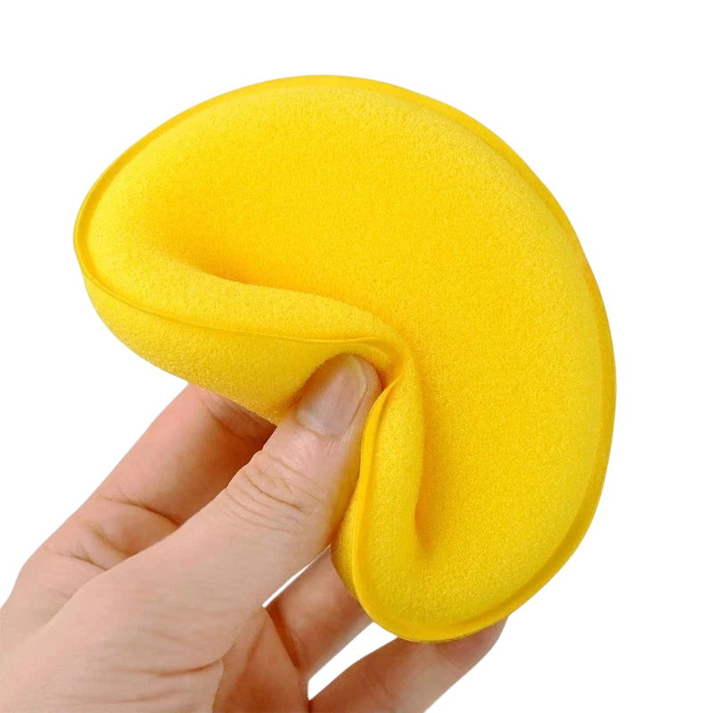 The Detail Warehouse yellow foam wax applicator being held and squeezed to show flexibility for car detailing