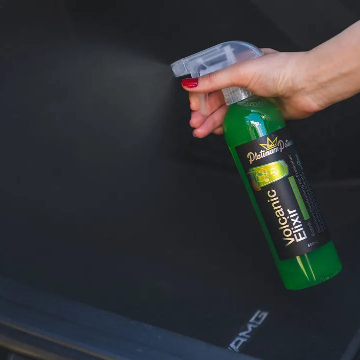 Person holding a green bottle labeled 'Oceanic Elixir' over a black surface